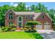 Beautiful brick home with a well-manicured lawn and mature trees at 545 Ashvale Overlook, Alpharetta, GA 30005