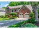 Charming brick home featuring a two-car garage and landscaped front yard at 545 Ashvale Overlook, Alpharetta, GA 30005