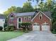 Charming two-story brick home with well-manicured lawn and a two car garage at 545 Ashvale Overlook, Alpharetta, GA 30005