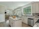 Open kitchen featuring granite counters, stainless appliances, and seamlessly connects to the dining area at 545 Ashvale Overlook, Alpharetta, GA 30005