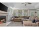 Comfortable living room with a fireplace, large windows, and a sectional sofa for relaxing or entertaining at 545 Ashvale Overlook, Alpharetta, GA 30005