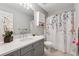 Bathroom featuring a gray vanity with quartz countertop, framed mirror, and decorative floral shower curtain at 3665 Magnolia Walk Trl, Cumming, GA 30040