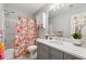 Well-lit bathroom features a shower-tub combo, vanity with a sink, and decorative accents at 3665 Magnolia Walk Trl, Cumming, GA 30040