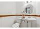 Half bath featuring tiled flooring, a toilet, and pedestal sink with framed mirror and light fixture at 3665 Magnolia Walk Trl, Cumming, GA 30040