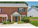 Charming brick townhome with a well-manicured front yard and inviting green front door at 3665 Magnolia Walk Trl, Cumming, GA 30040