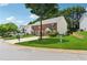 Street view of a brick townhome featuring a manicured lawn and mature shade trees at 3665 Magnolia Walk Trl, Cumming, GA 30040