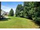 Expansive green backyard with lush trees providing privacy and shade, beautiful landscaping at 1496 Clarecastle Ln, Buford, GA 30519