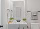 Neutral bathroom features a white single sink vanity and a decorative mirror at 1496 Clarecastle Ln, Buford, GA 30519