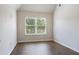 Bright bedroom with hardwood floors, large window, and neutral paint at 1496 Clarecastle Ln, Buford, GA 30519