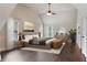 Well-lit primary bedroom with a ceiling fan, windows, and hardwood flooring at 1496 Clarecastle Ln, Buford, GA 30519