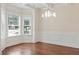 Bright dining room with hardwood floors, decorative wainscoting, chandelier, and large windows at 1496 Clarecastle Ln, Buford, GA 30519