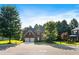 Beautiful two-story brick home with a two-car garage surrounded by mature trees and a well-manicured lawn at 1496 Clarecastle Ln, Buford, GA 30519