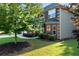 Side view of a well-maintained two-story brick home, showing manicured landscaping and green lawn at 1496 Clarecastle Ln, Buford, GA 30519