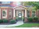 Inviting front porch with decorative columns, a wreath on the door, and potted plants, adding curb appeal at 1496 Clarecastle Ln, Buford, GA 30519