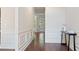 Hallway featuring hardwood floors, wainscoting, and a view to the outdoors, enhancing the home's elegance at 1496 Clarecastle Ln, Buford, GA 30519