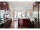 Modern kitchen with stainless appliances, dark wood cabinets, and access to breakfast nook at 1496 Clarecastle Ln, Buford, GA 30519