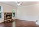 Cozy living room showcasing a stone fireplace, hardwood floors, and a ceiling fan at 1496 Clarecastle Ln, Buford, GA 30519