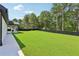Expansive backyard featuring manicured lawn, mature trees, and privacy fencing provides ample space at 3205 Bold Springs Rd, Dacula, GA 30019