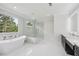 Bright bathroom featuring a soaking tub, walk-in shower, marble accents, and dual vanity at 3205 Bold Springs Rd, Dacula, GA 30019
