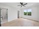 Bright bedroom featuring hardwood floors, a ceiling fan, and multiple windows overlooking a tree lined lot at 3205 Bold Springs Rd, Dacula, GA 30019
