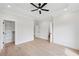 Airy bedroom with tray ceilings, light hardwood floors, neutral paint, and multiple doorways to additional closets at 3205 Bold Springs Rd, Dacula, GA 30019