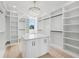 Spacious closet featuring built-in shelves, a center island, and a decorative chandelier at 3205 Bold Springs Rd, Dacula, GA 30019
