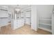 Large walk-in closet with custom shelving, center island, and elegant lighting for optimal storage at 3205 Bold Springs Rd, Dacula, GA 30019