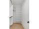 Walk in closet featuring hardwood floors, white shelving and black hardware at 3205 Bold Springs Rd, Dacula, GA 30019