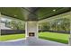 Outdoor covered patio showcasing a brick fireplace, dark-stained wood ceiling, and a view of the backyard at 3205 Bold Springs Rd, Dacula, GA 30019