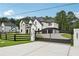 Elegant two-story home with white brick, black trim, gated entrance, and a professionally landscaped yard at 3205 Bold Springs Rd, Dacula, GA 30019