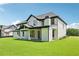 Spacious backyard featuring lush green grass, modern white brick home with a covered patio perfect for entertaining at 3205 Bold Springs Rd, Dacula, GA 30019