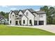 Beautiful two-story home with a white brick facade, dark trim, attached garage, and meticulously kept lawn at 3205 Bold Springs Rd, Dacula, GA 30019