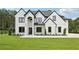 Stunning two-story home featuring a painted brick exterior, dark trim, arched entryway, and manicured lawn at 3205 Bold Springs Rd, Dacula, GA 30019
