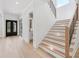 Light-filled foyer with staircase, paneled walls, wood floors, and views of the front door at 3205 Bold Springs Rd, Dacula, GA 30019