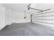 A large garage with epoxy flooring, featuring an open garage door and custom built-in shelving for storage at 3205 Bold Springs Rd, Dacula, GA 30019