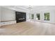 Bright living room features wood floors, fireplace, and built-in storage with modern chandelier at 3205 Bold Springs Rd, Dacula, GA 30019