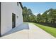 Concrete patio with black door and black fence along the lush lawn and abundant trees at 3205 Bold Springs Rd, Dacula, GA 30019