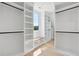 Spacious walk-in closet featuring custom white shelving, a bench, and ample storage space for organization at 3205 Bold Springs Rd, Dacula, GA 30019