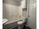 Bathroom with tub and shower, and storage cabinet above the toilet at 4044 Robin Cir, Atlanta, GA 30349
