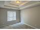Bedroom with tray ceiling, neutral walls, large window, and carpet flooring at 4044 Robin Cir, Atlanta, GA 30349