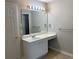 This bathroom includes a single sink vanity with storage and a large mirror with lighting at 646 Lakes Cir, Lithonia, GA 30058