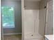 This bathroom features a white shower, window, and neutral tile floor at 646 Lakes Cir, Lithonia, GA 30058