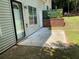 Small concrete patio with black framed sliding door and small privacy fence attached at 646 Lakes Cir, Lithonia, GA 30058
