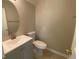 Stylish powder room with gray vanity, modern faucet, mirror, and toilet at 646 Lakes Cir, Lithonia, GA 30058