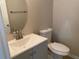 Stylish powder room with gray vanity, modern faucet, mirror, and toilet at 646 Lakes Cir, Lithonia, GA 30058