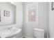 Bright powder room featuring a pedestal sink, toilet, and window at 322 Peters Sw St # 2, Atlanta, GA 30313