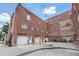 Brick apartment building featuring ground-level garages and direct access doors, with dumpster area at 322 Peters Sw St # 2, Atlanta, GA 30313