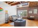 Bright, modern living room with exposed ceilings, a brick accent wall, and hardwood floors at 322 Peters Sw St # 2, Atlanta, GA 30313