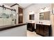 Modern bathroom with double sinks, white marbled countertops, dark cabinets, and glass shower at 4882 Rabbit Farm Road Rd, Loganville, GA 30052