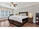 A spacious bedroom featuring a large bed with drawer storage, a ceiling fan, and hardwood floors at 4882 Rabbit Farm Road Rd, Loganville, GA 30052